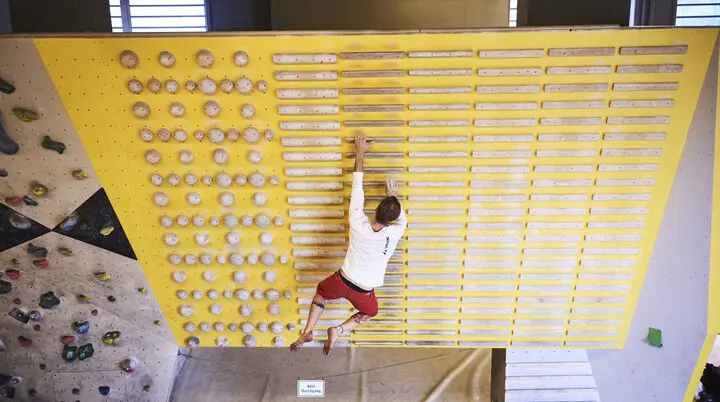 Ein Mann beim Training an einem gelben Campusboard. | © DAV/Frank Kretschmann
